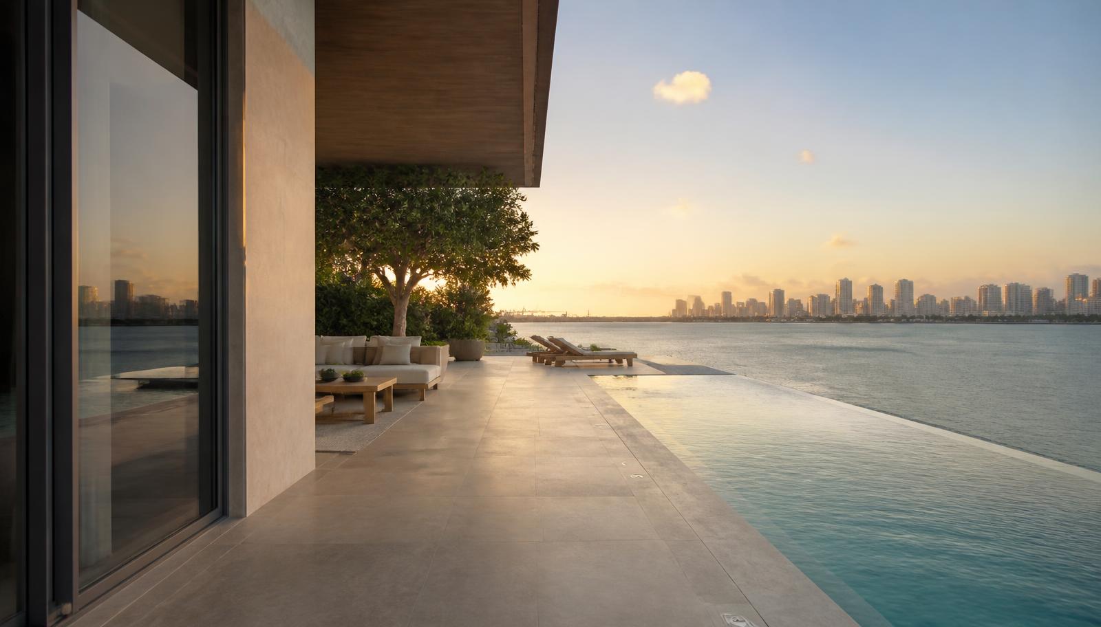 Terraço de uma casa à beira-mar em Miami com piscina e vista para a baía ao entardecer